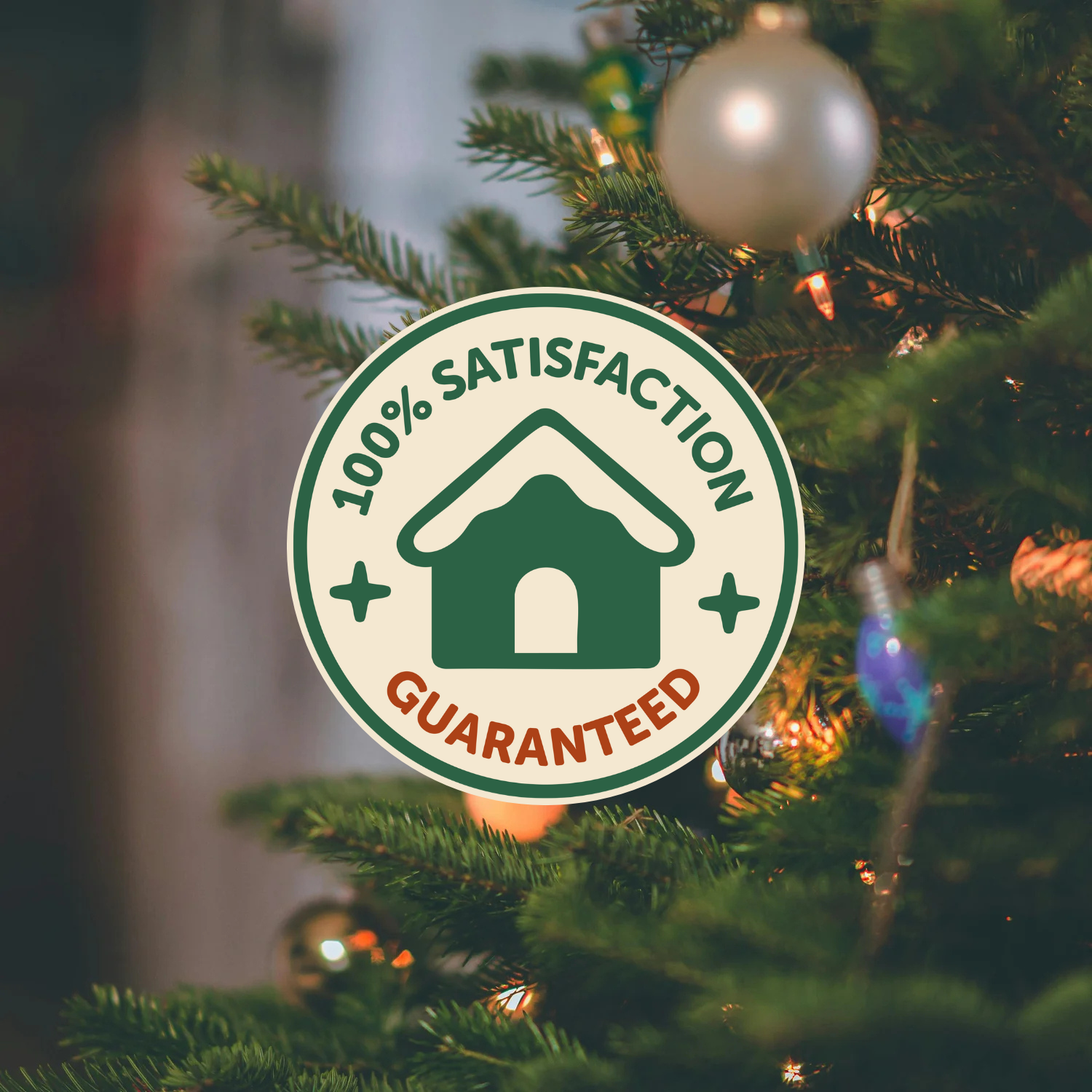 Decorative sticker on a Christmas tree with '100% Satisfaction Guaranteed' text.