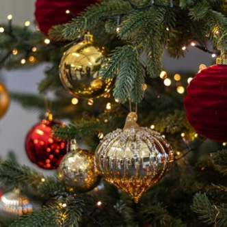 Decorative Christmas tree with gold, red, and silver ornaments.